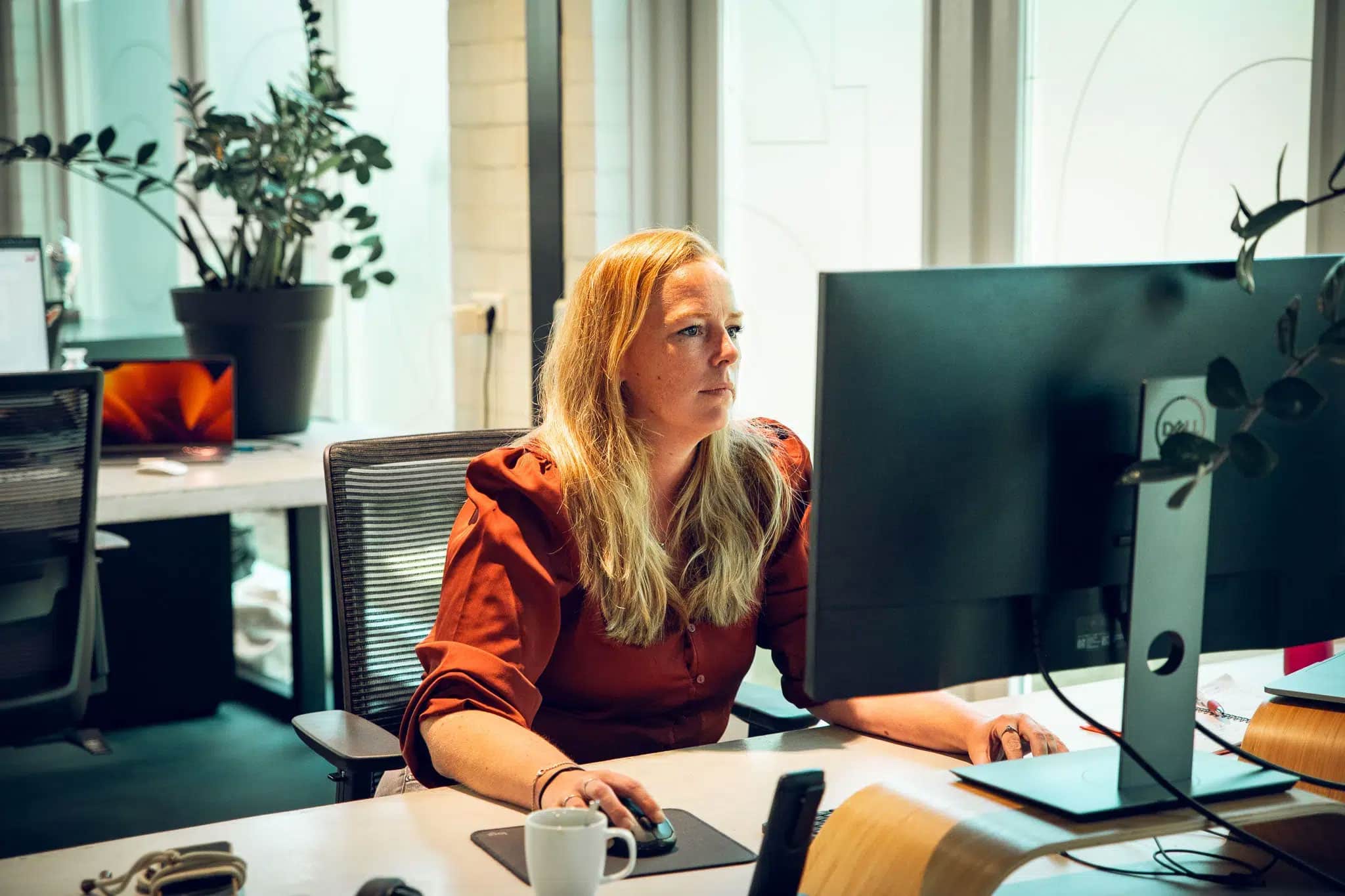 Collega aan het werk achter haar computer op het kantoor in Bergeijk.