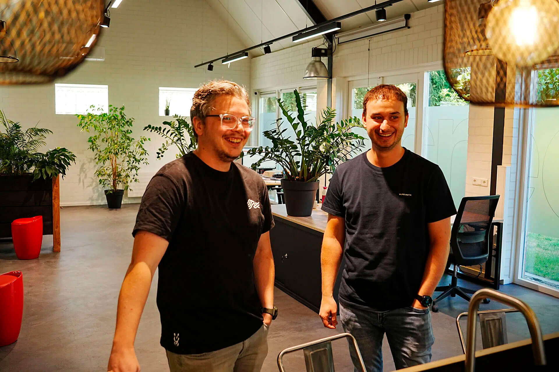 2 collega's lachend op het kantoor.