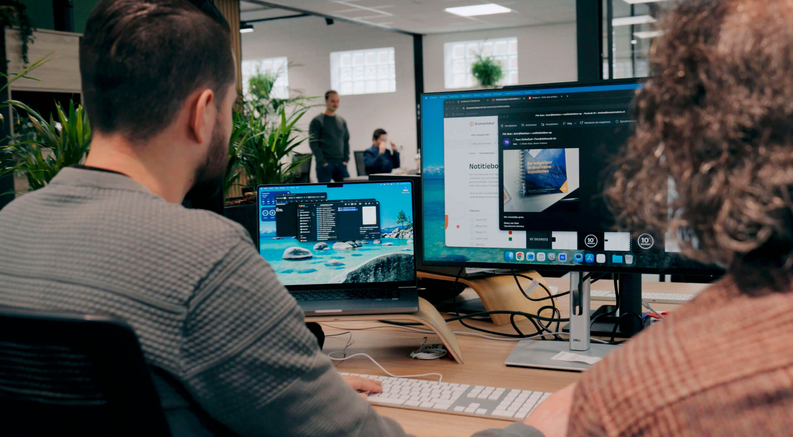 2 medewerkers samen aan het werk aan een merkstrategie achter een computer.