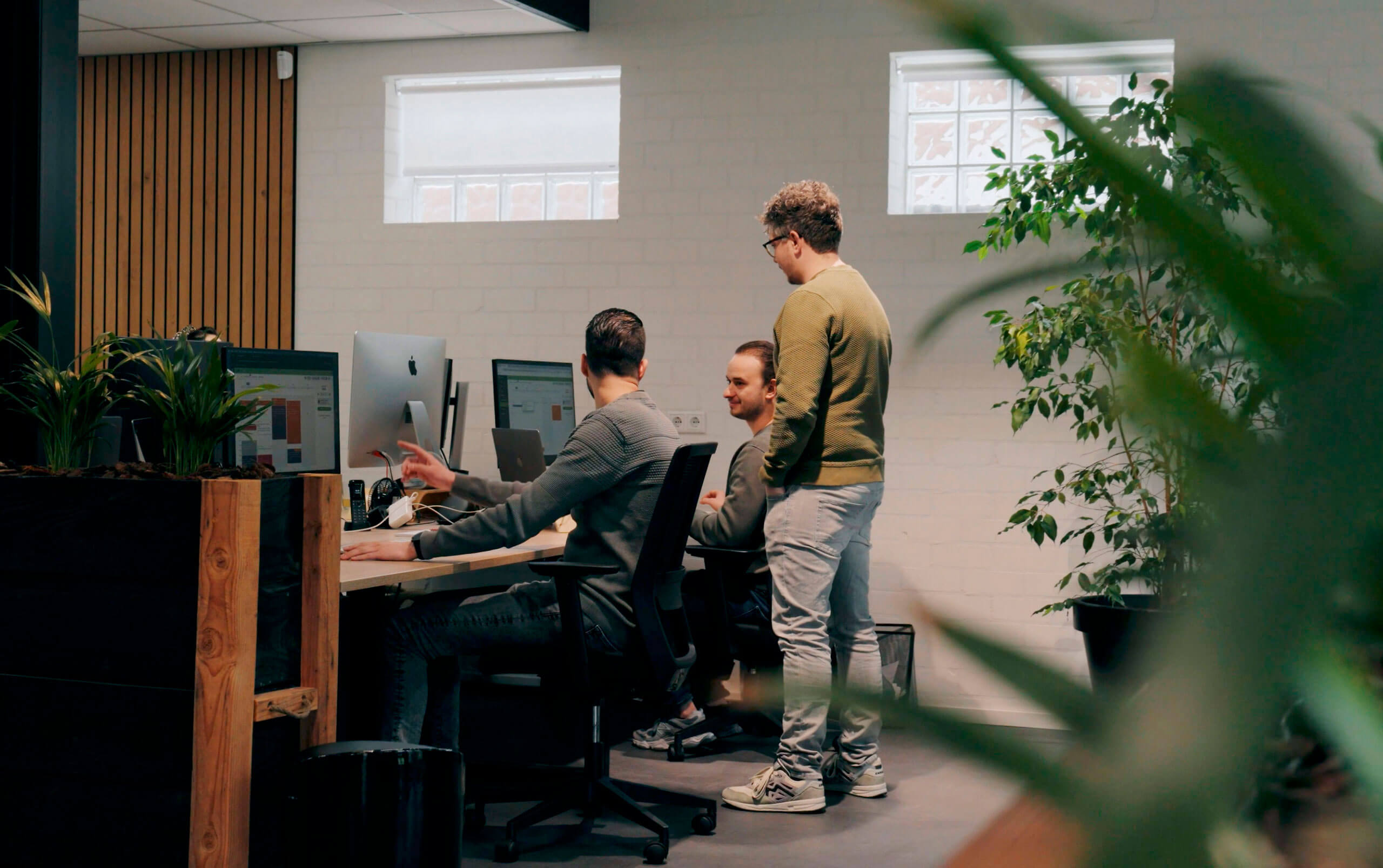 3 collega's die een overleg hebben over een merkstrategie.