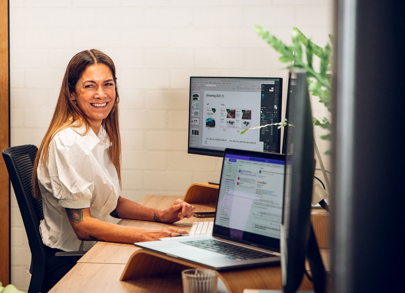 Medewerker lachend achter haar computer.