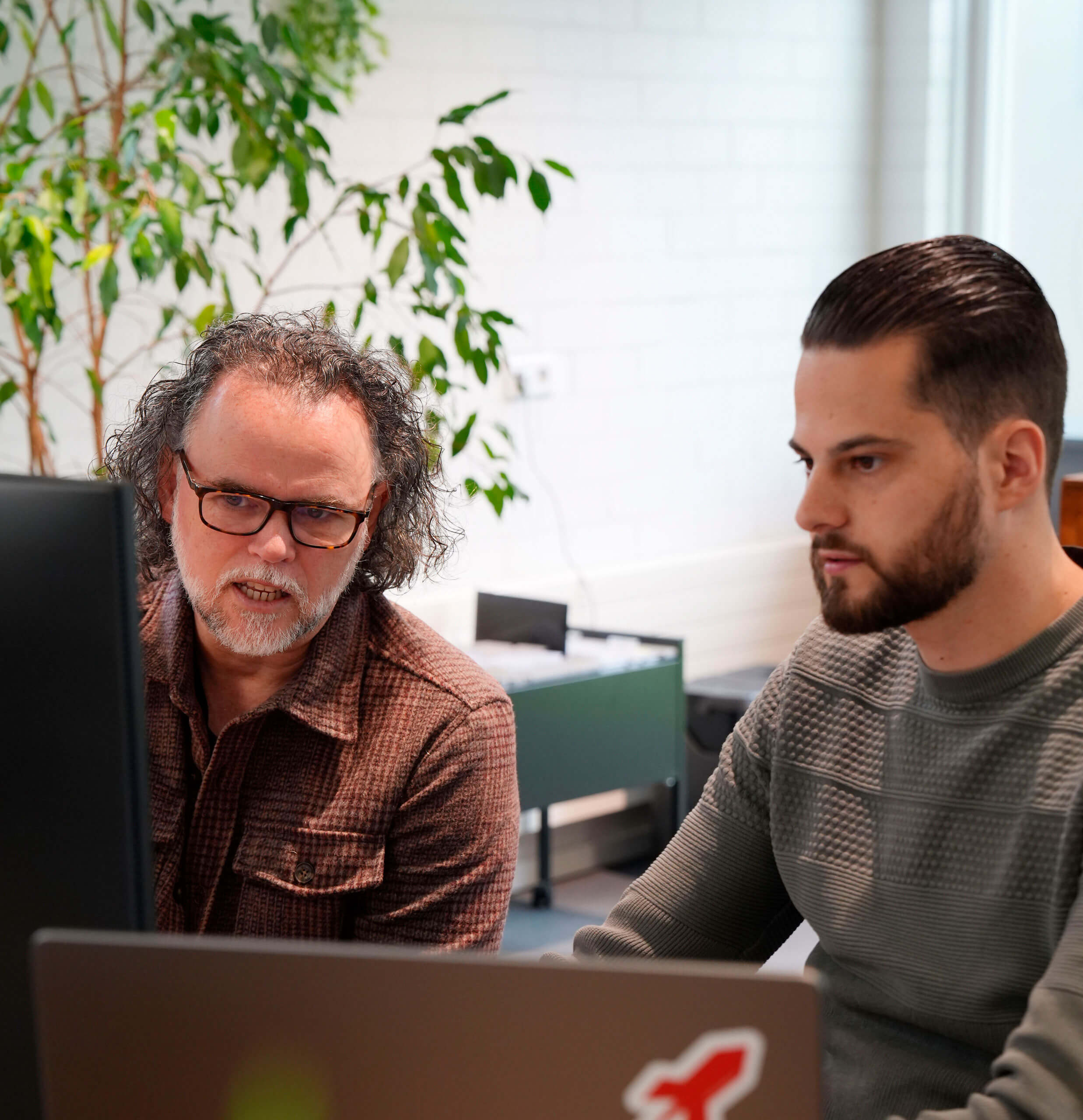 2 medewerkers die aan het overleggen zijn over een merkstrategie.