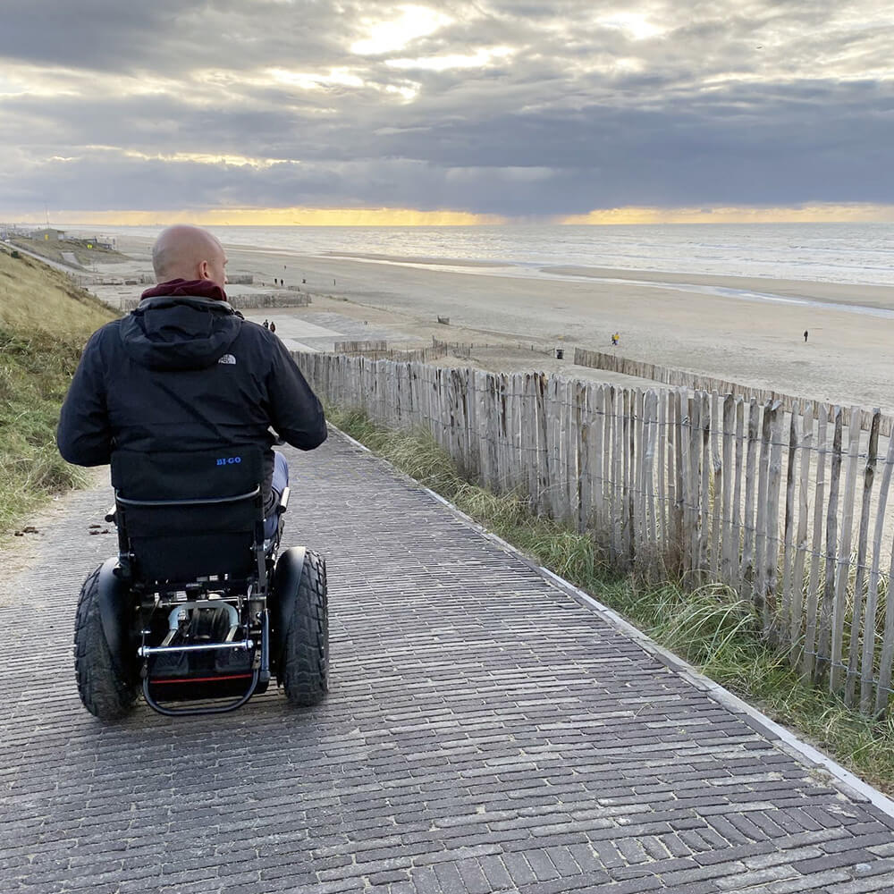 man op off-road rolstoel aan strand